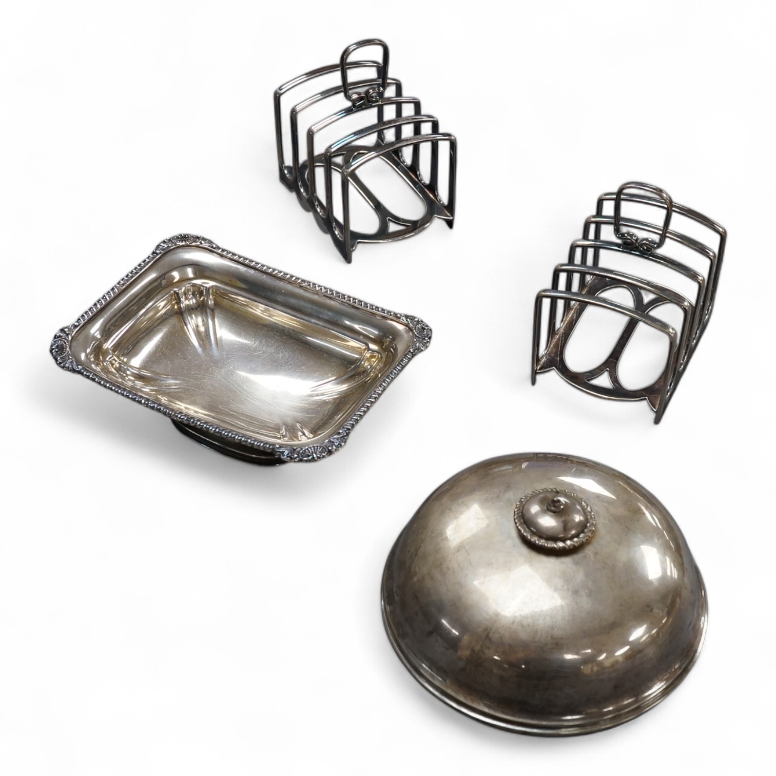 A pair of George V silver five bar toast racks, by Atkin Brothers, Sheffield, 1912, length 94mm, together with a silver muffin dish lid and a silver pedestal bonbon dish, 26.2ox
